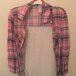 A pink flannel sweater that has lace in the back